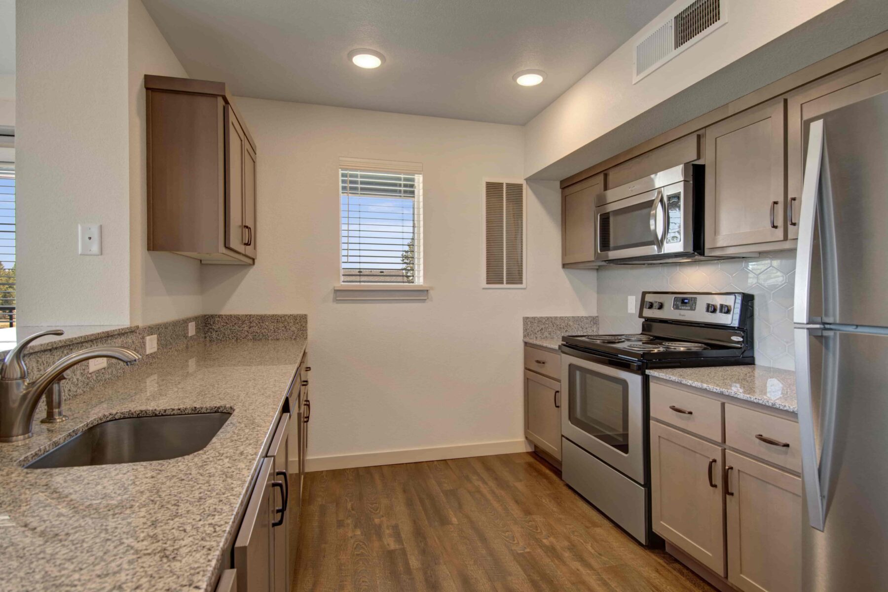 Kitchen with stainless steel appliances, granite countertops, and light brown cabinets