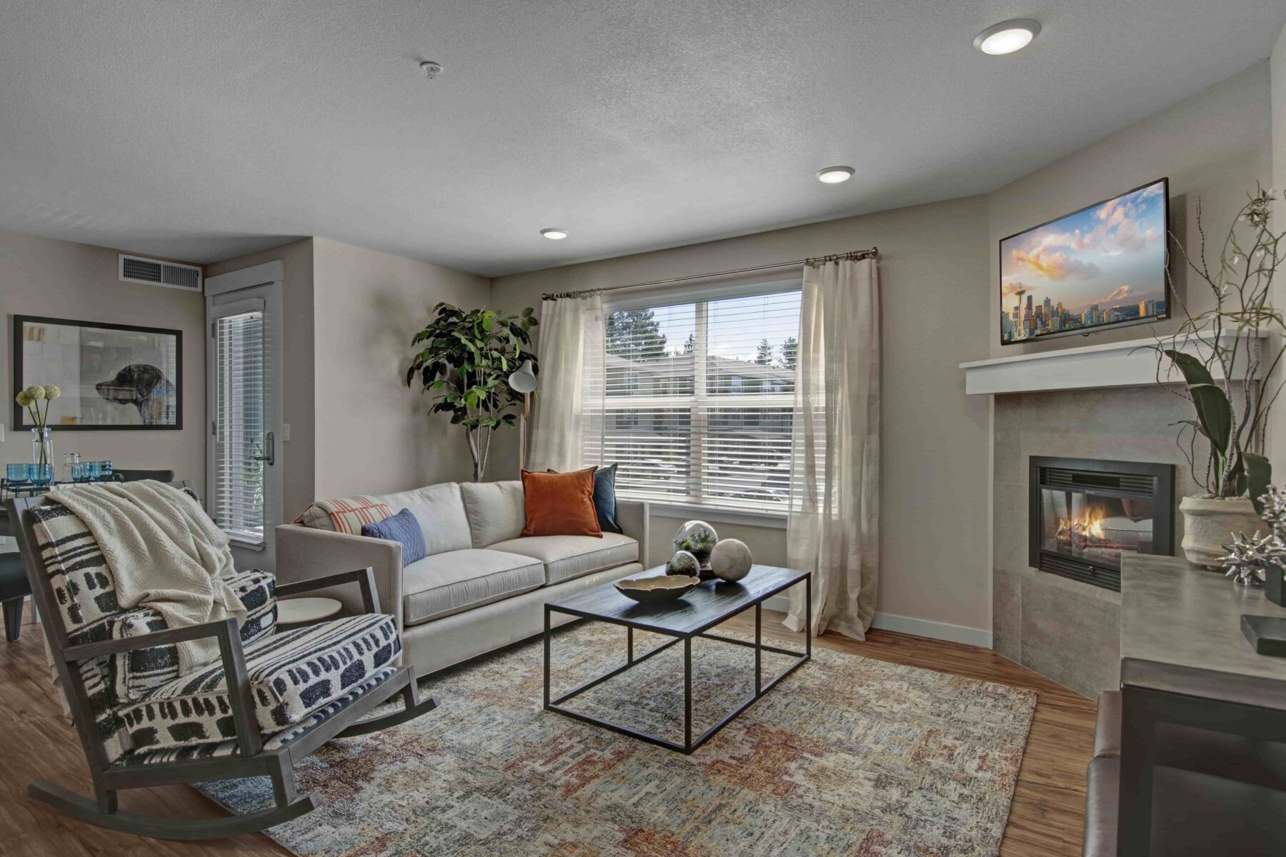 Open living room with large window and fireplace